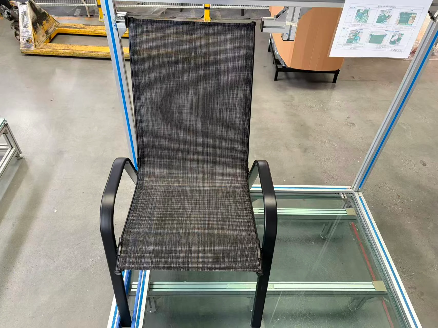 A chair is checked on a leveled fixture before production, including backrest alignment and secure fasteners.